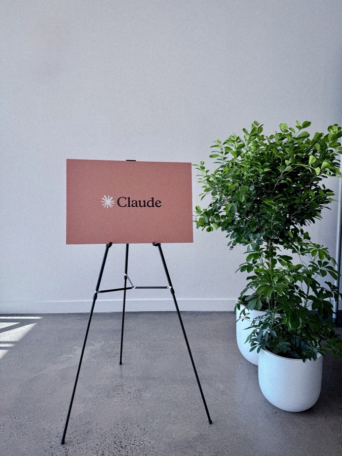 Claude workshop sign with a plant in the room